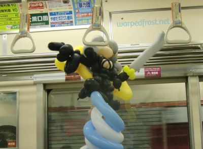 Balloon Seph hanging on to a strap on the train
